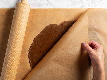 Pâte à biscuit abaissée entre deux feuilles de papier parchemin